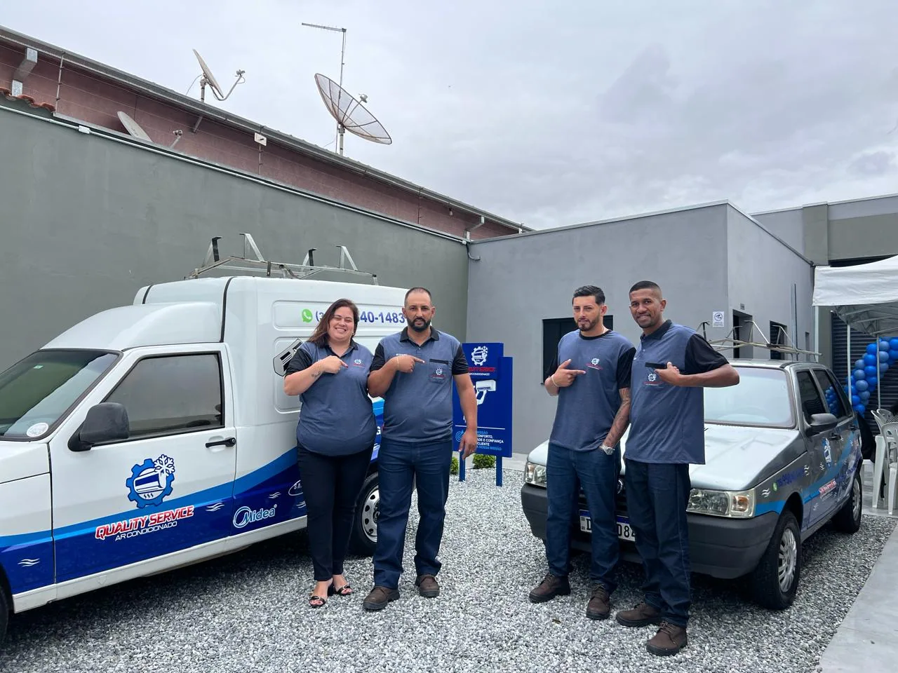 Equipe da Quality Service uniformizada ao lado dos veículos da empresa