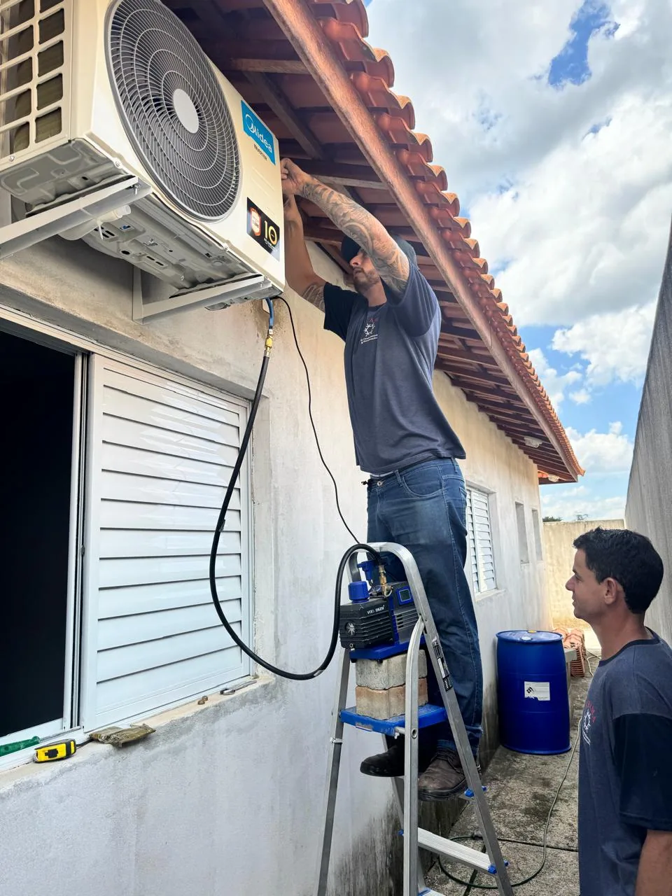 Técnico da Quality Service instalando a unidade condensadora de um ar condicionado com bomba de vácuo